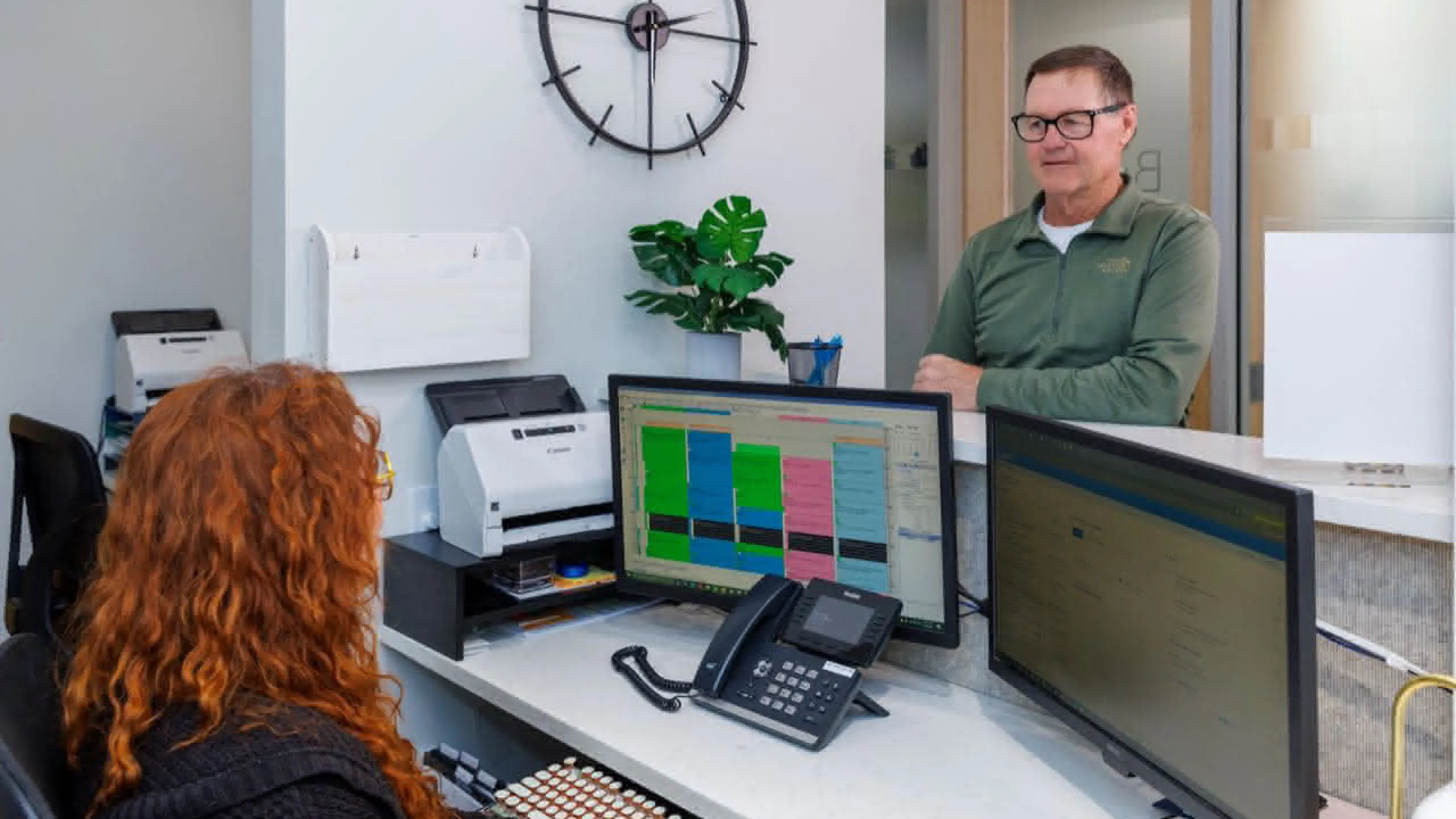 Front desk with patient speaking to staff