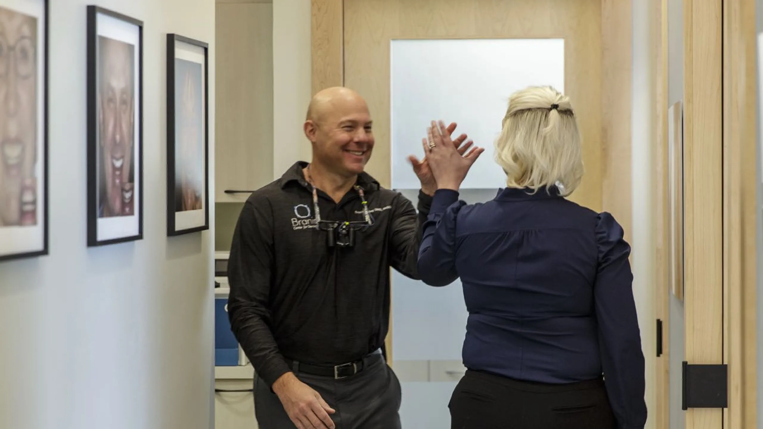 Two doctors high fiving in the hallway
