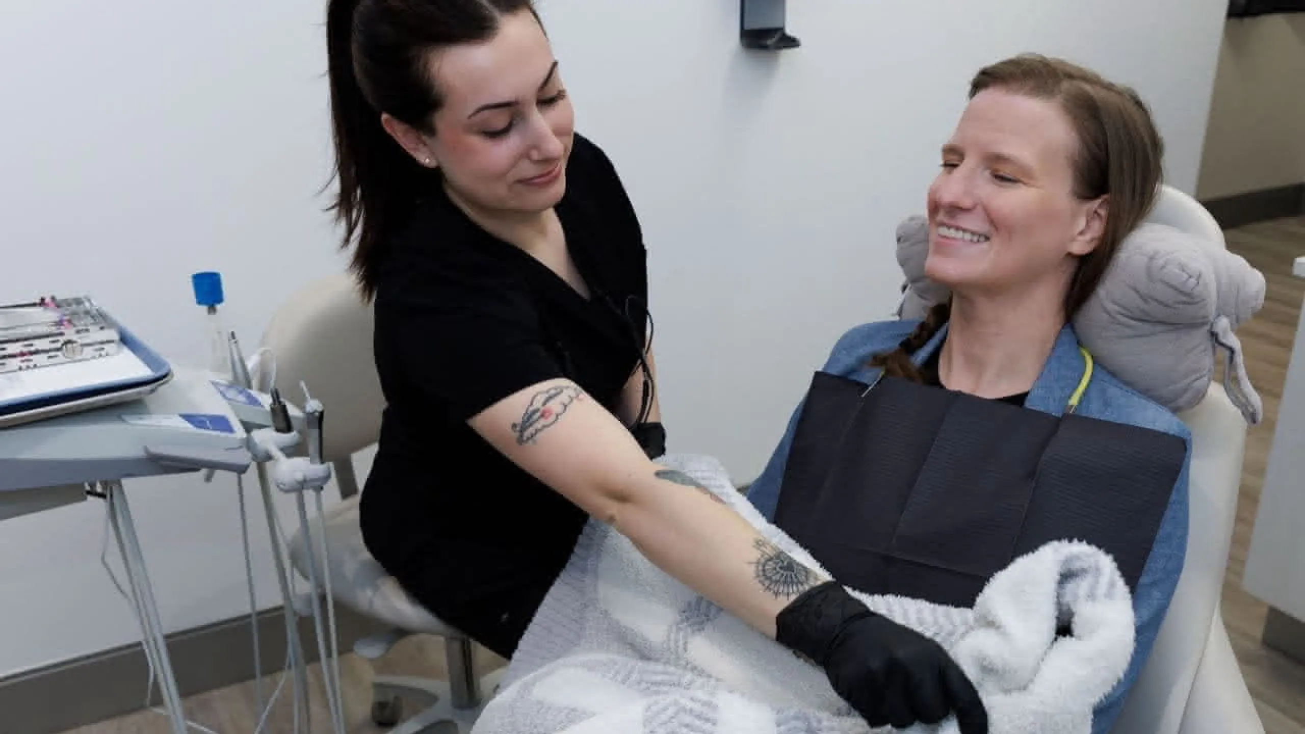 Staff member adjusting a blanket on a patient