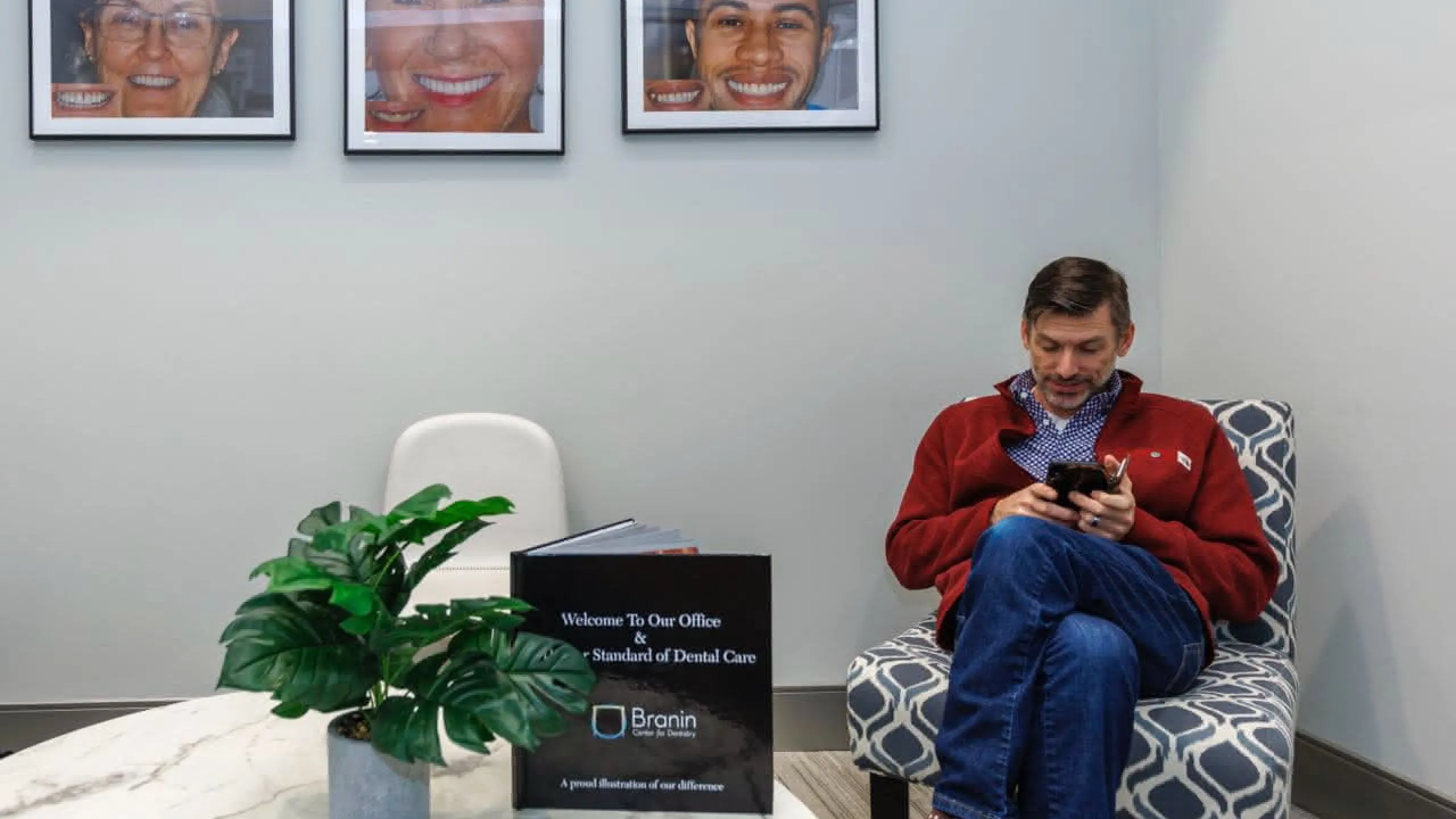 A patient in a chair in the lobby looking at a phone