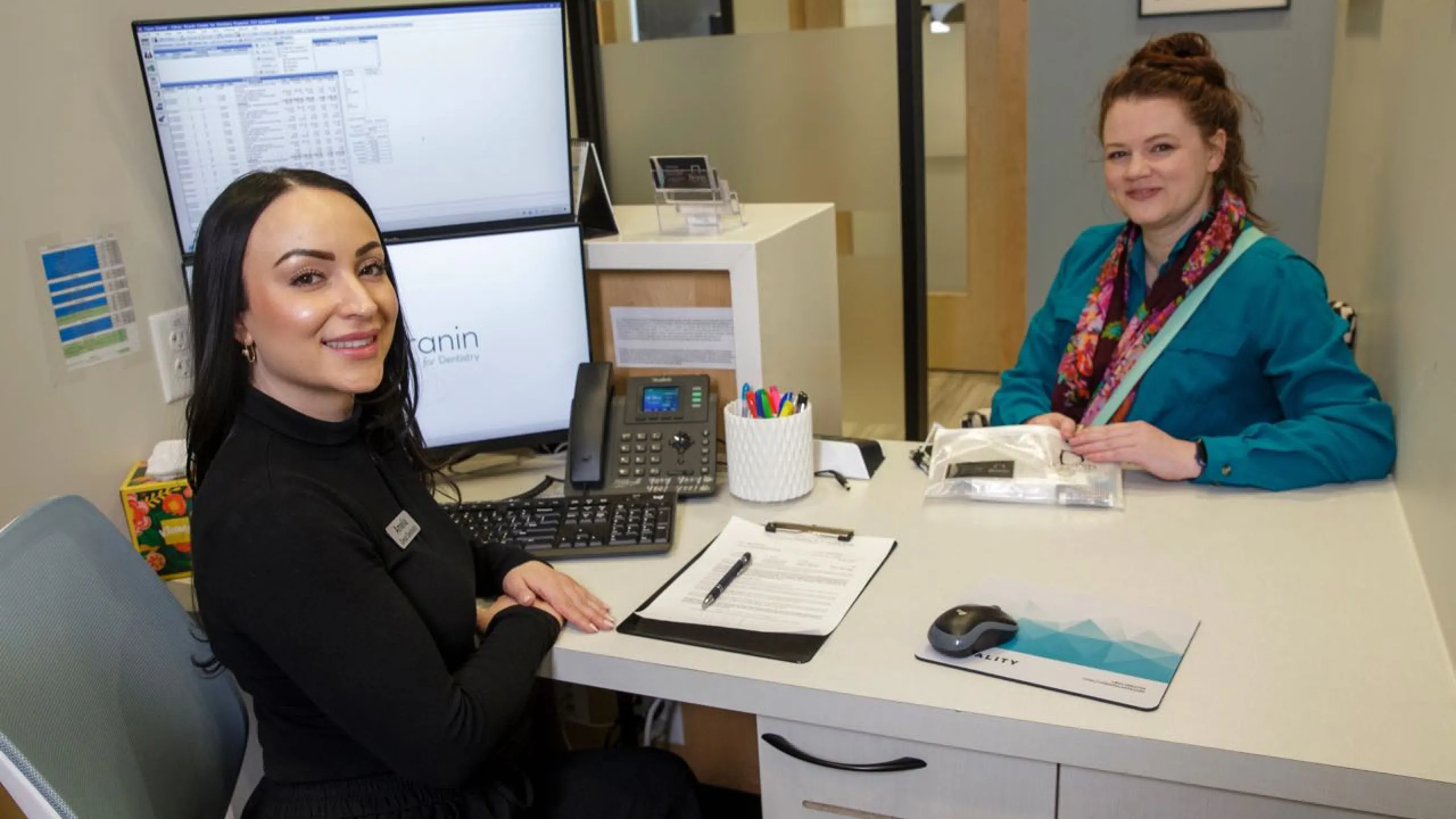 Patient meets with staff member at a white desk