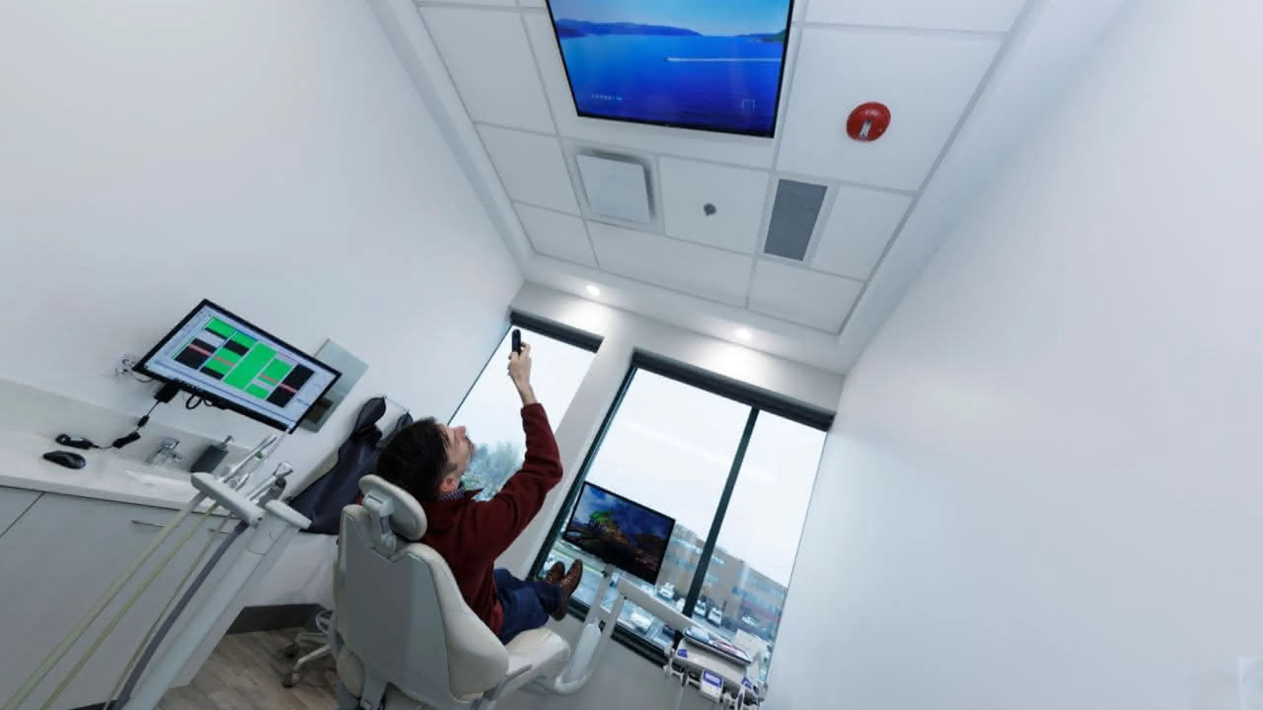 A patient in a chair looking at a monitor on the ceiling