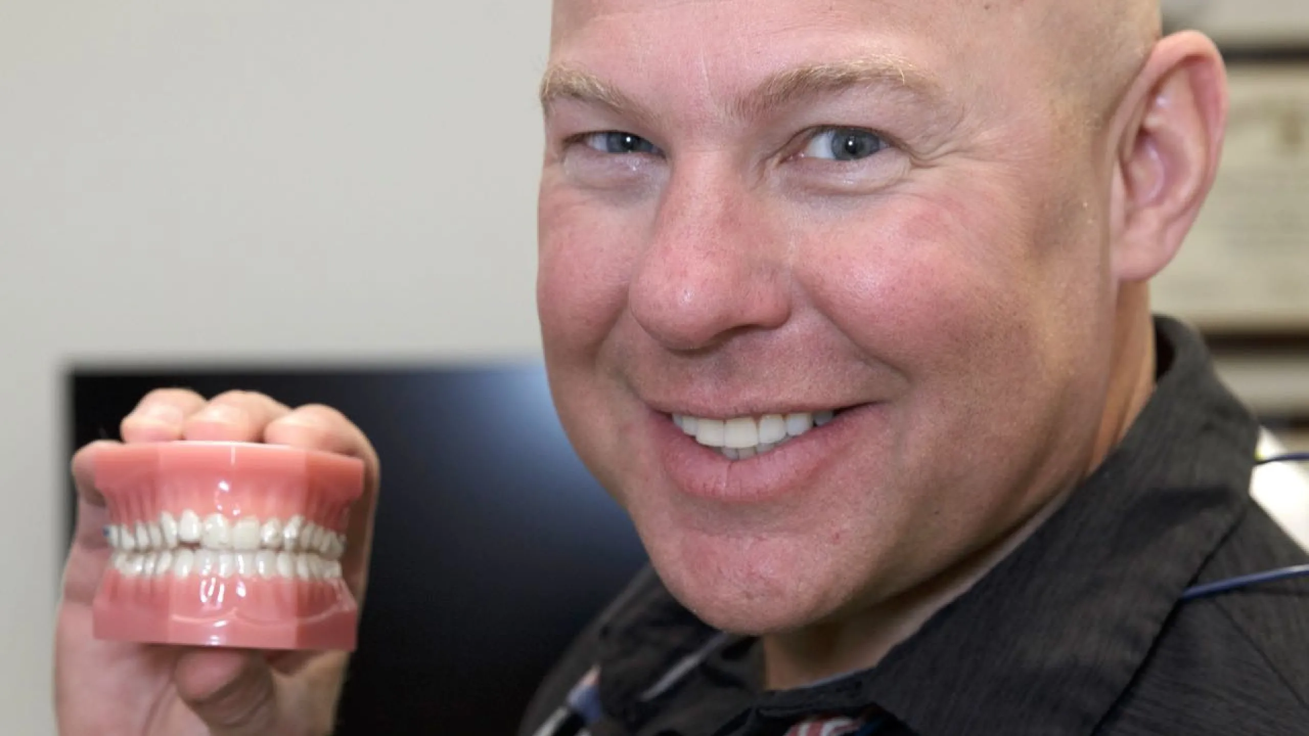 Dr. Dudley holding a set of teeth