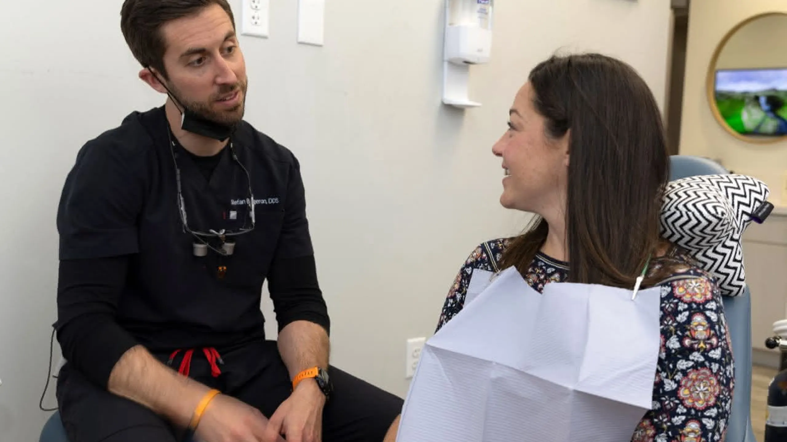Dentist sitting with patient discussing procedures