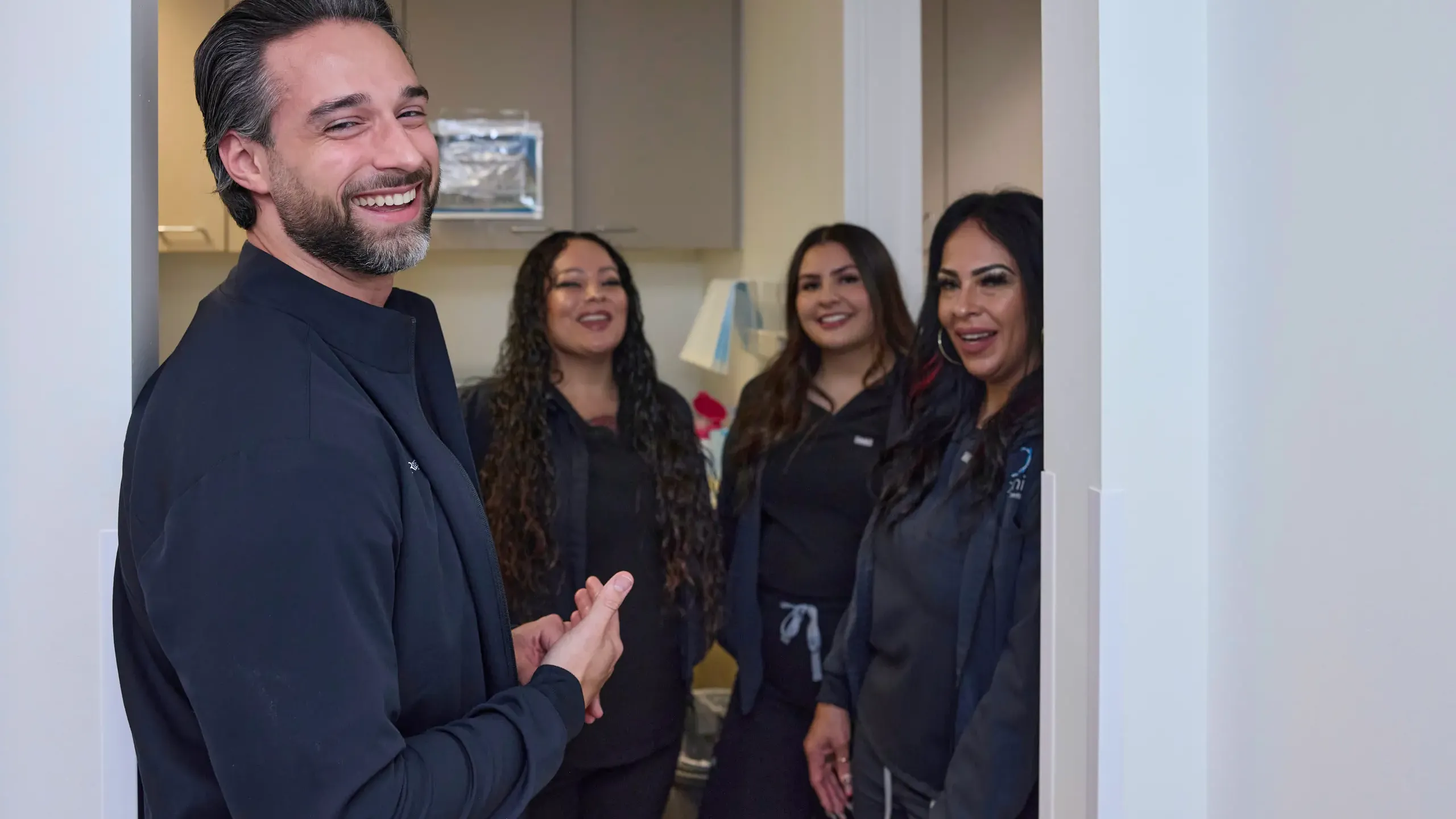 A doctor in a doorway with team