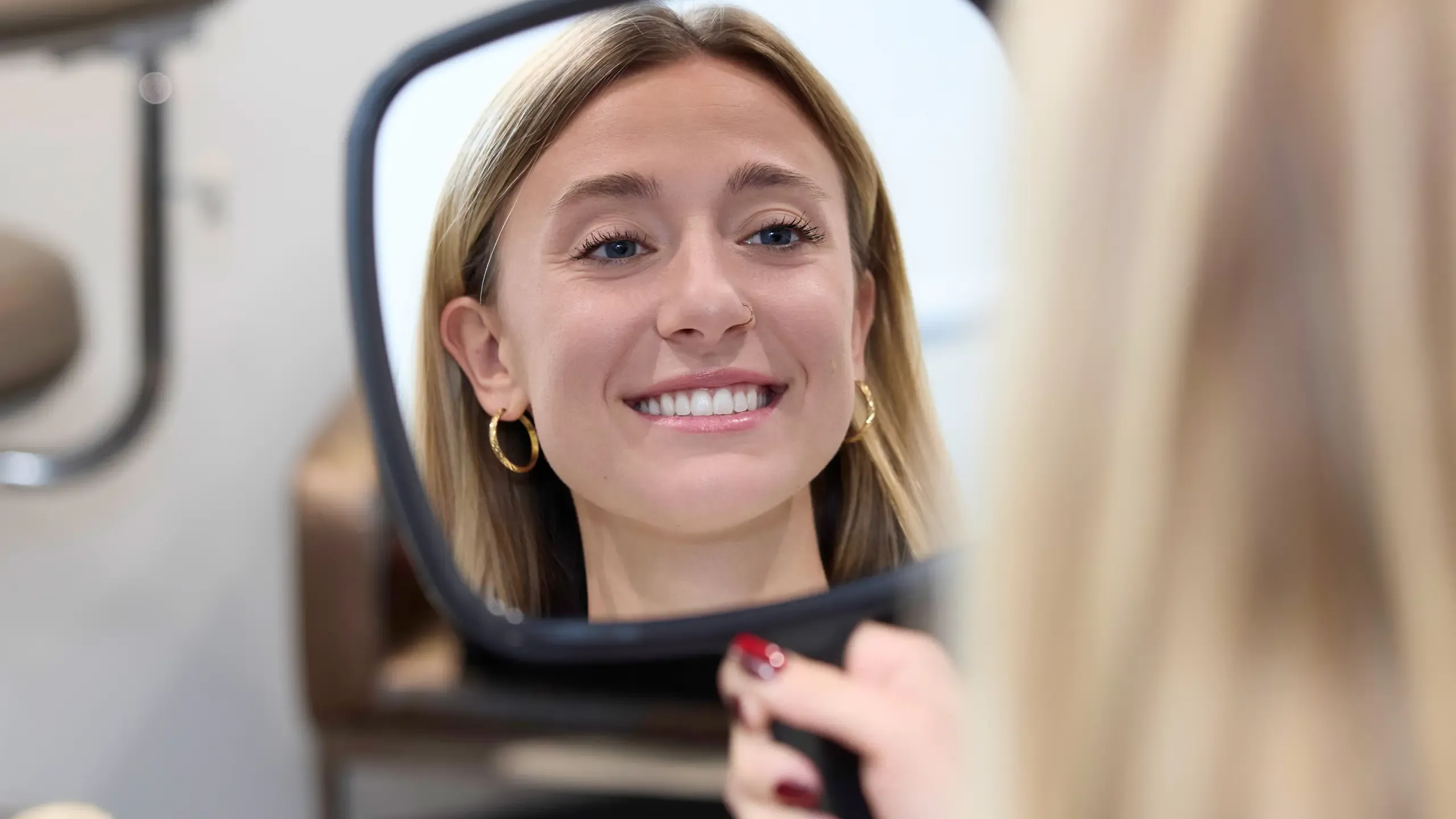 A patient looking at themselves in a hand mirror