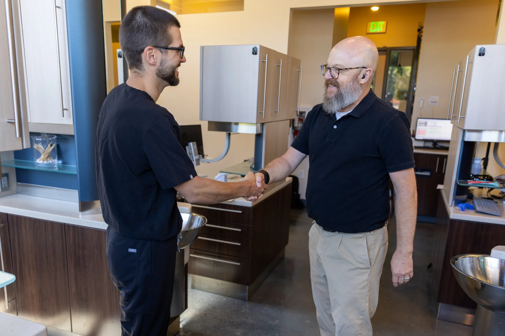 Dr. Staffen shaking hands with a smiling patient
