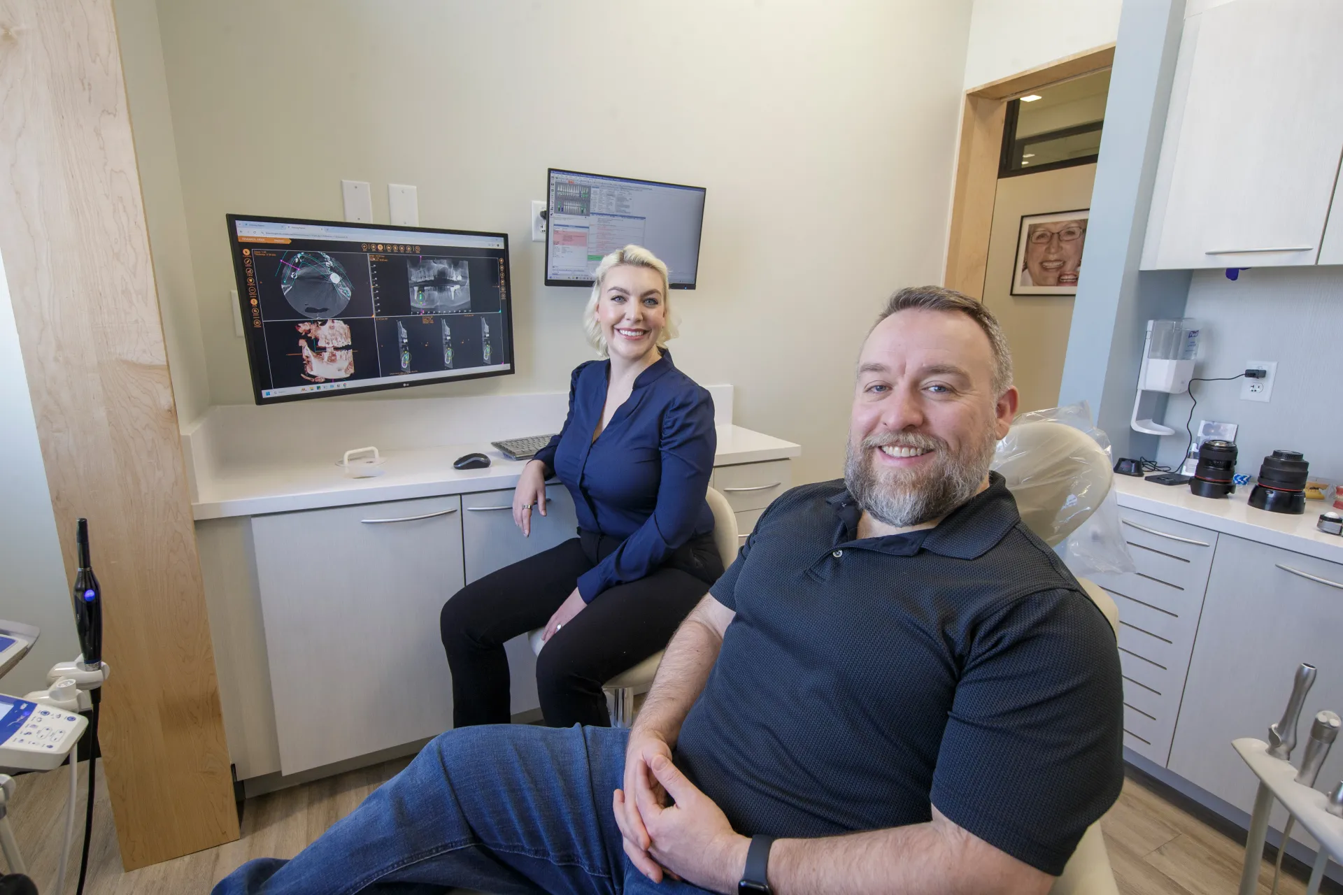 Dr. Sesson and a smiling patient sitting together in the operatory.
