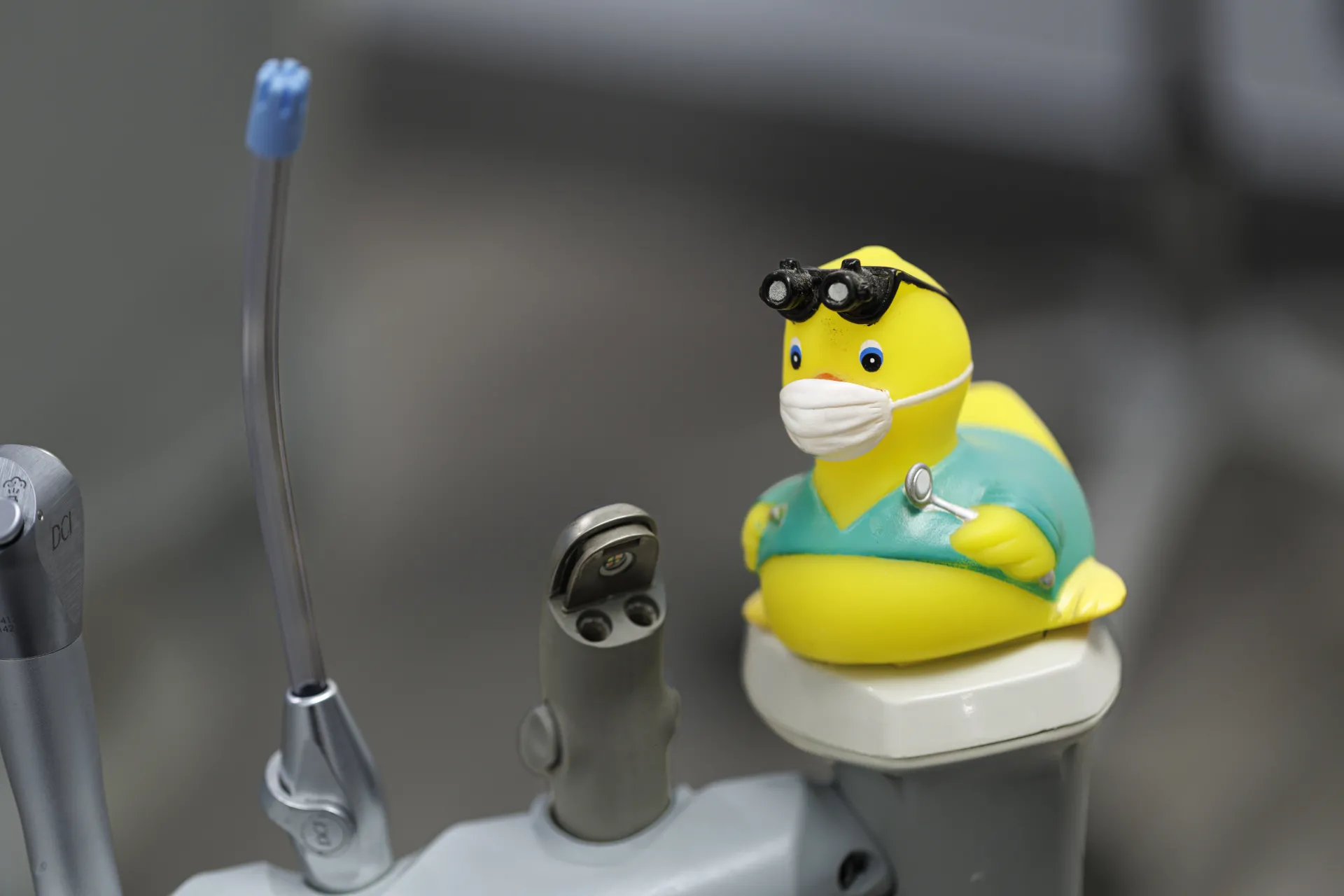 photo of a rubber ducky that looks like a dentist with a mask on, glasses, and dentist tools