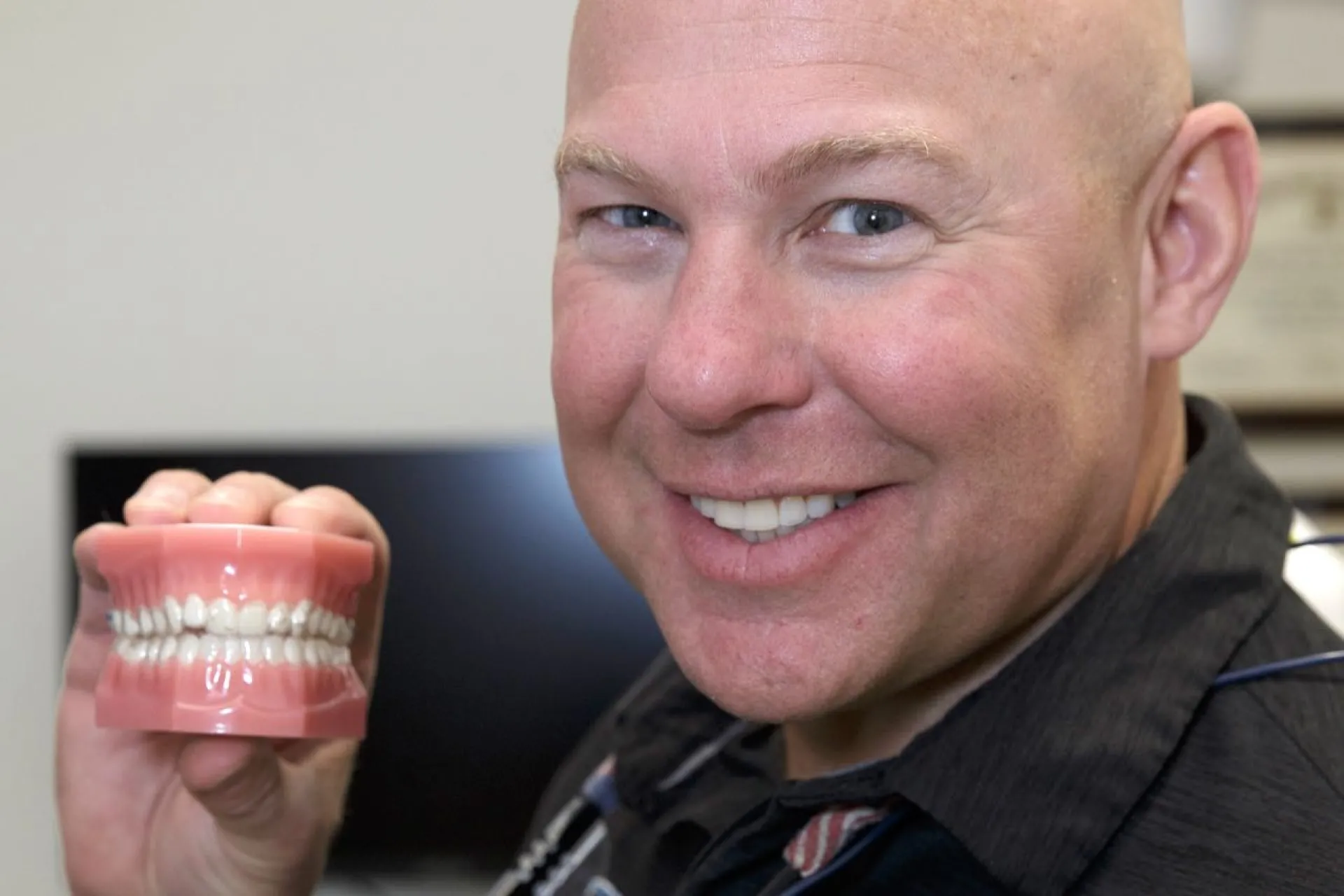 Dr. Dudley holding a set of teeth