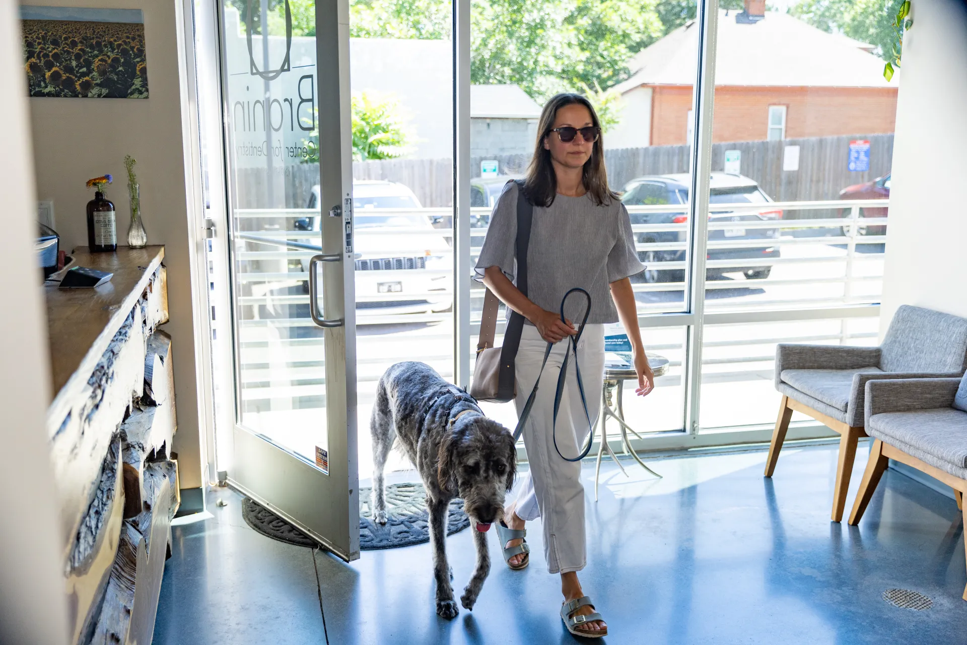 A patient walking into the office with a dog companion