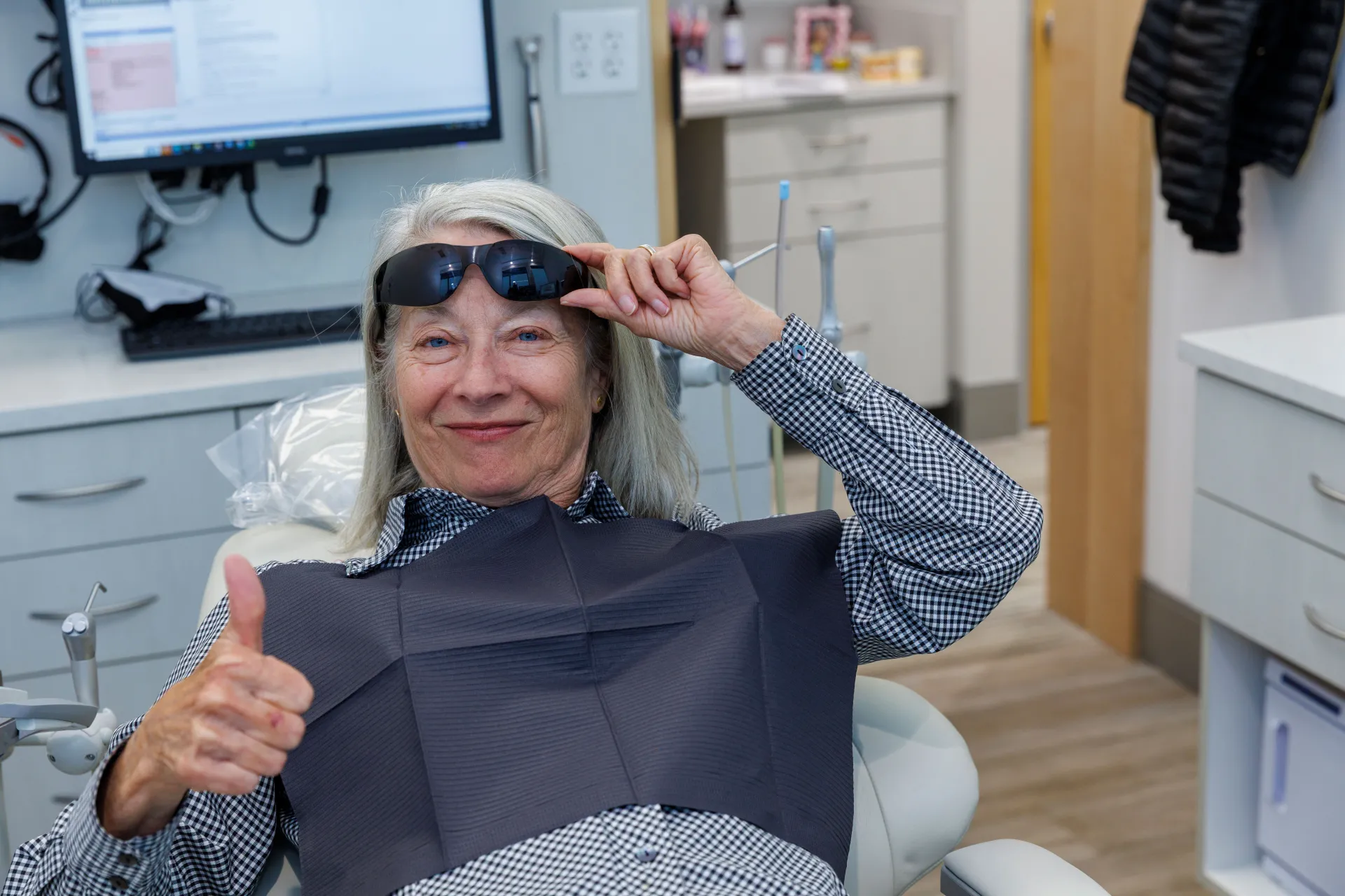 A smiling patient giving a thumbs up