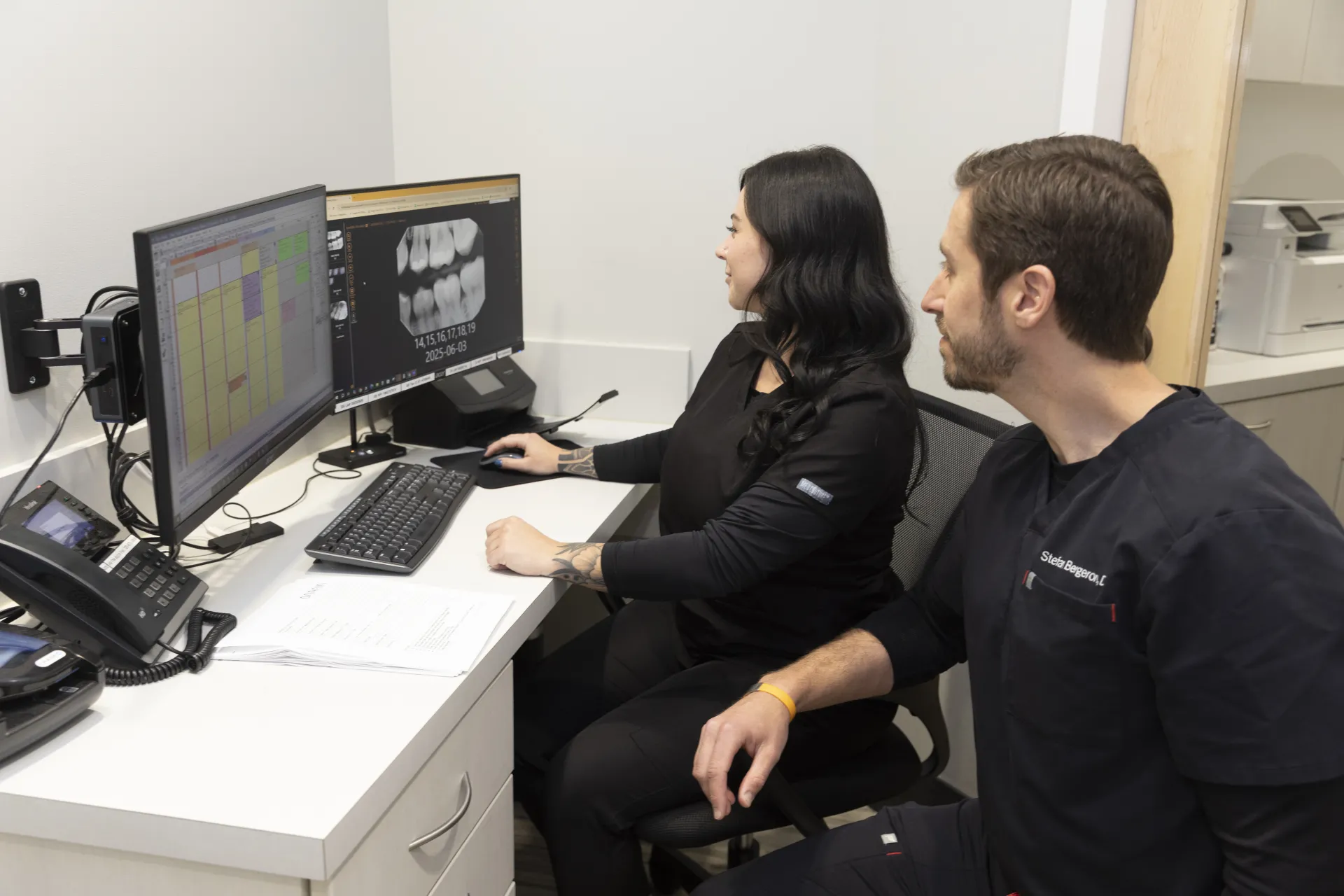 Dr. Staffen and an employee looking at pictures of a patient's teeth