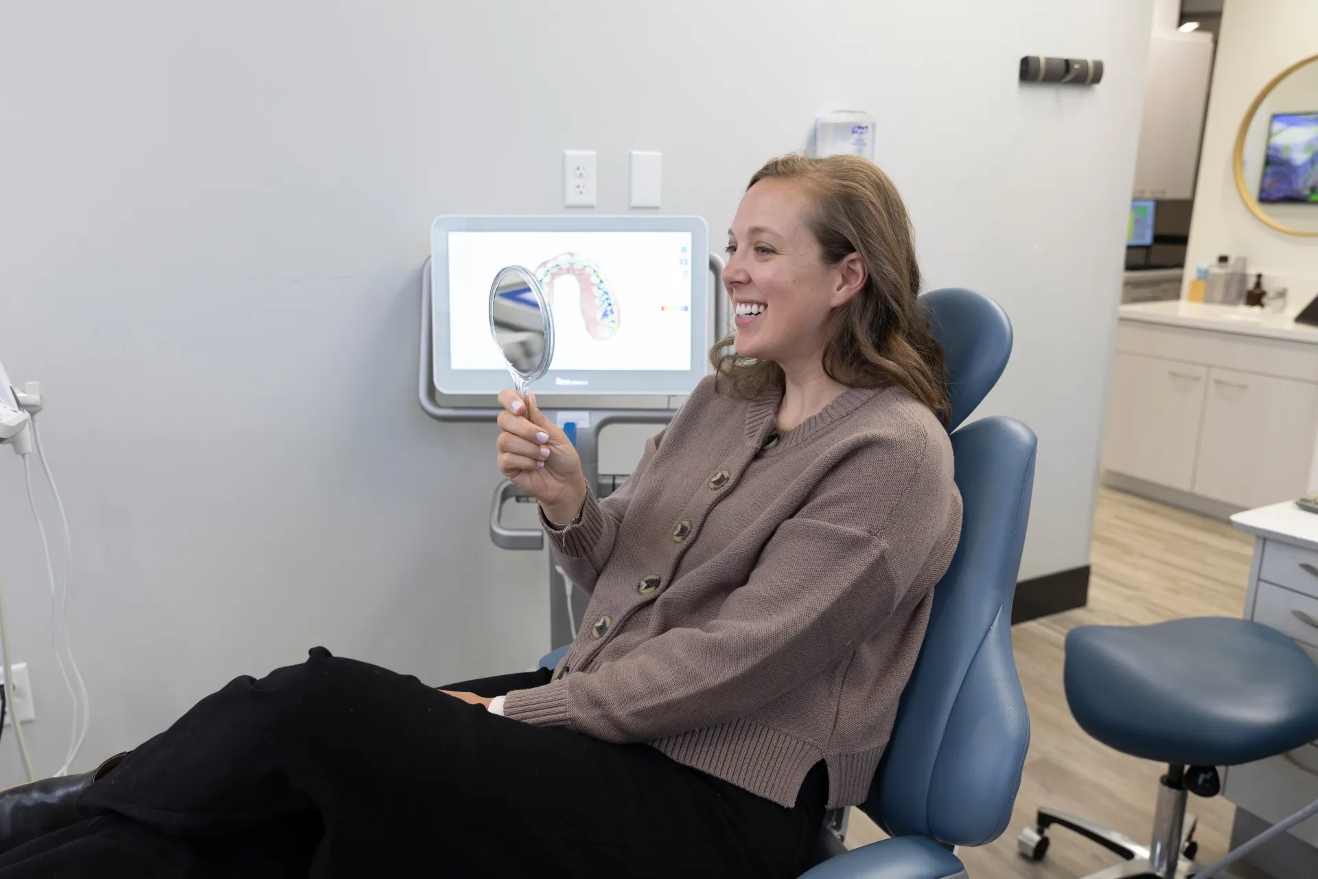 A patient smiling holding a mirror