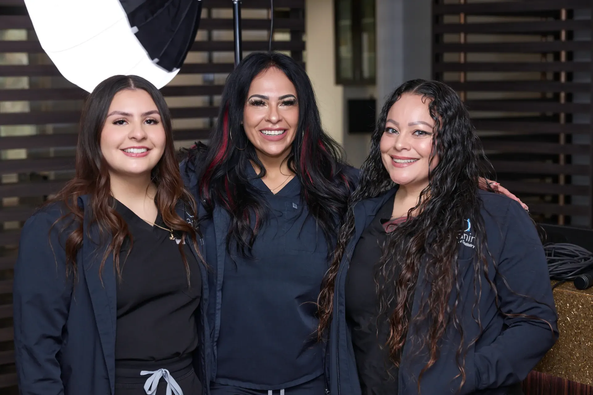 Three team members in front of a round mirror