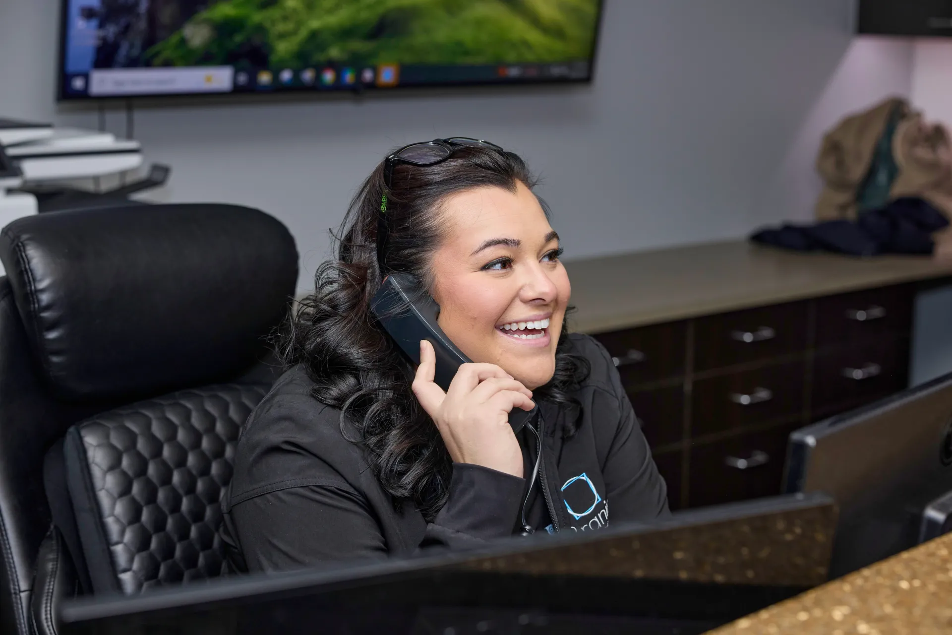 An employee smiling as she answers the phone
