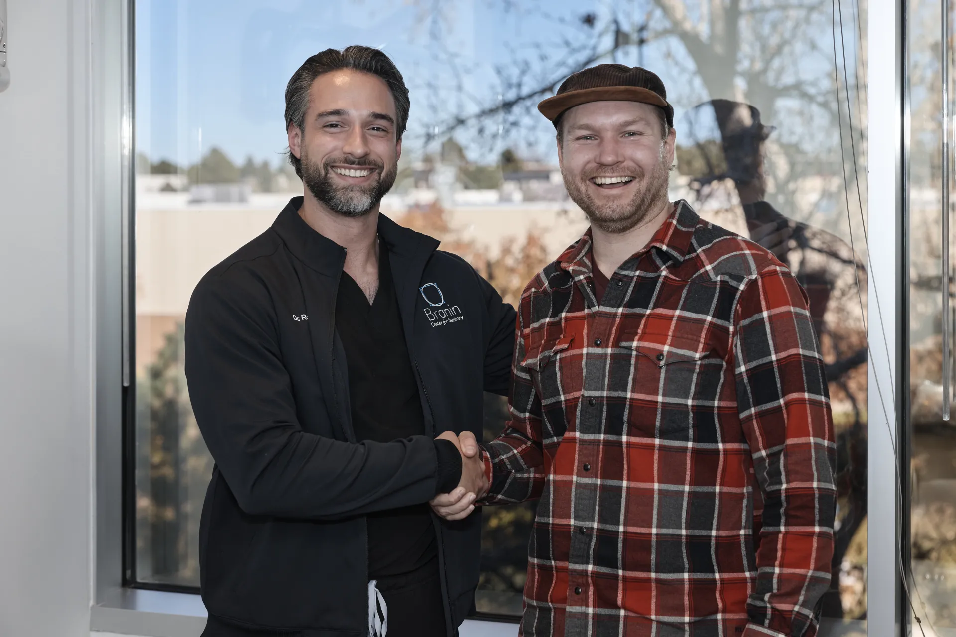 Dr. Rogers shaking hands with a happy patient
