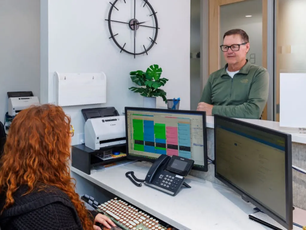 Front desk with patient speaking to staff