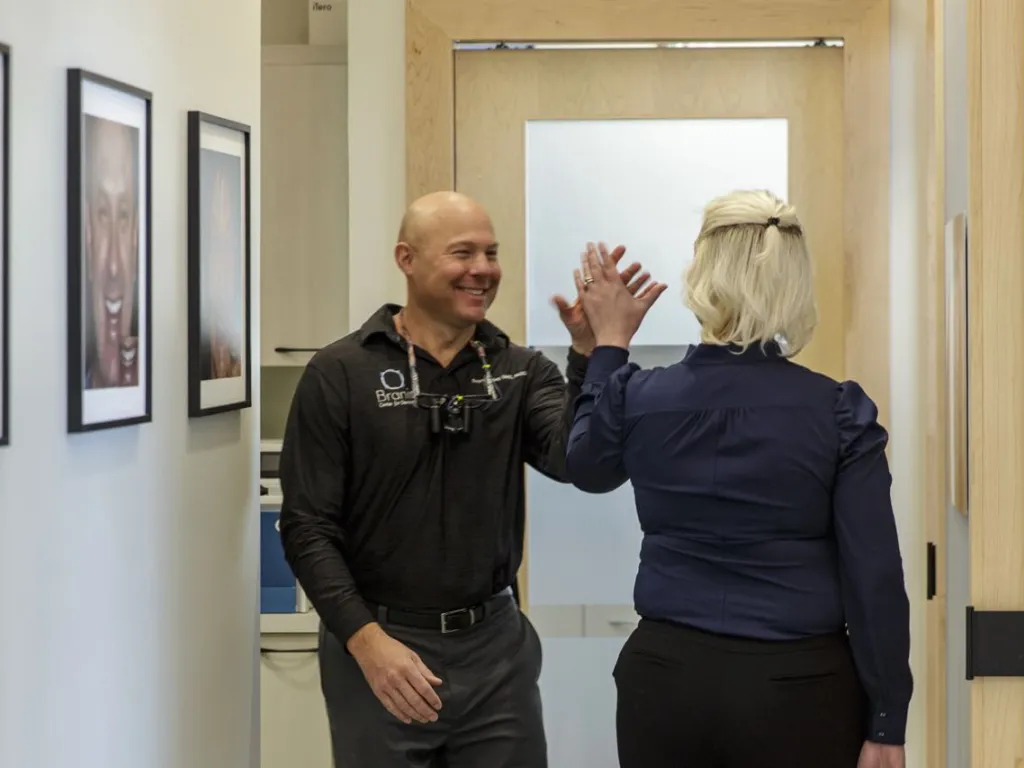 Two doctors high fiving in the hallway