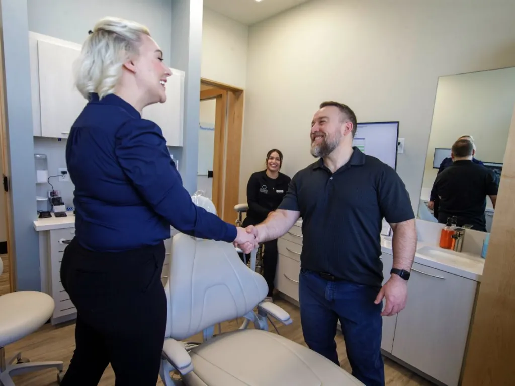 A patient shaking hands with Dr. Sesson