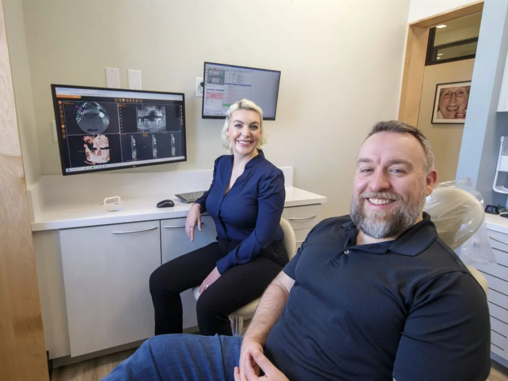 Dr. Sesson and a patient smiling in a dental suite