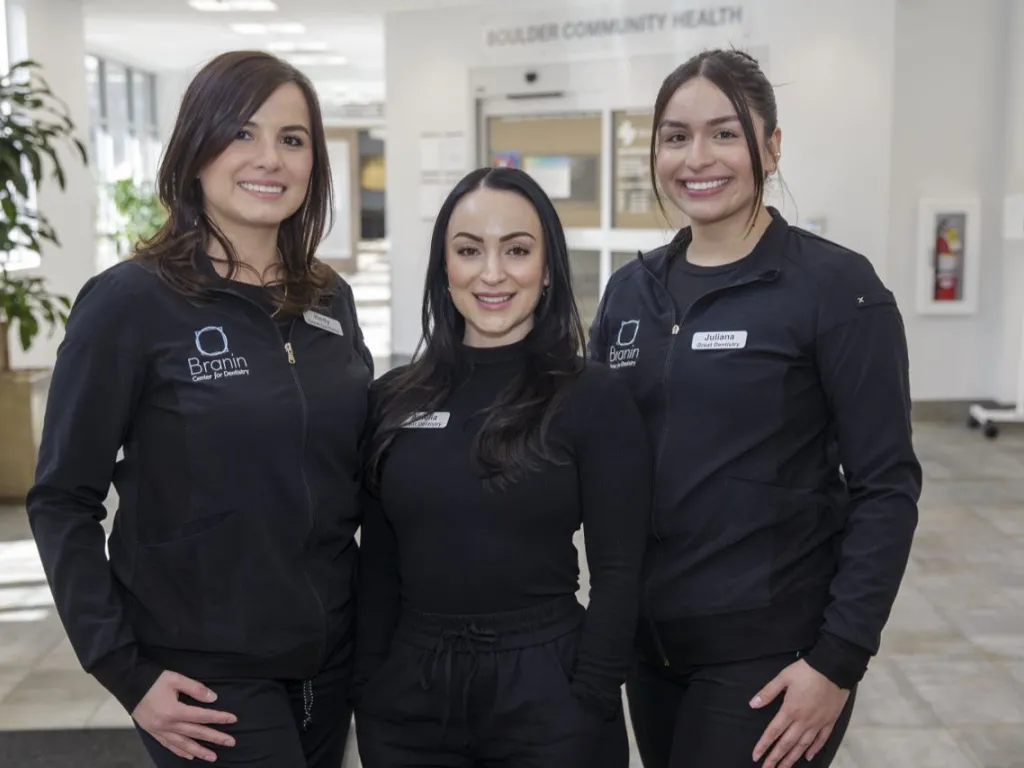 Three staff members standing in the lobby
