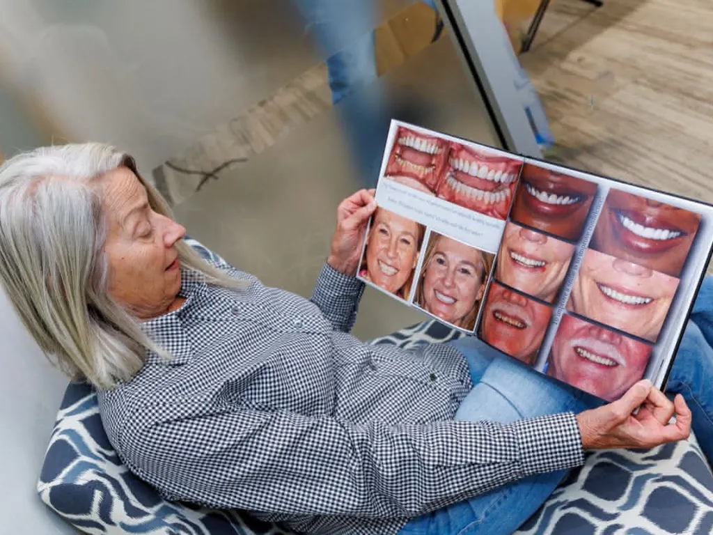 Patient looking at a book with smile examples