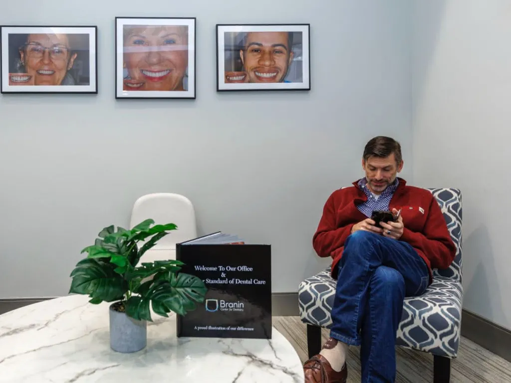 A patient in a chair in the lobby looking at a phone