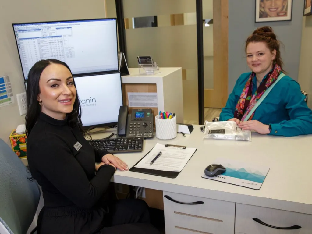 Patient meets with staff member at a white desk
