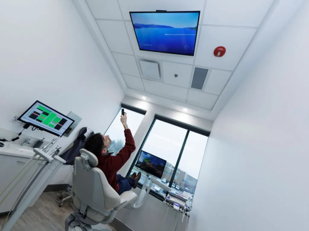 A patient in a chair looking at a monitor on the ceiling