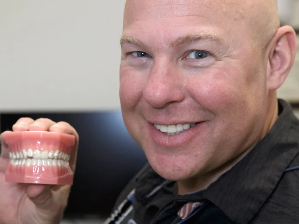 Dr. Dudley holding a set of teeth
