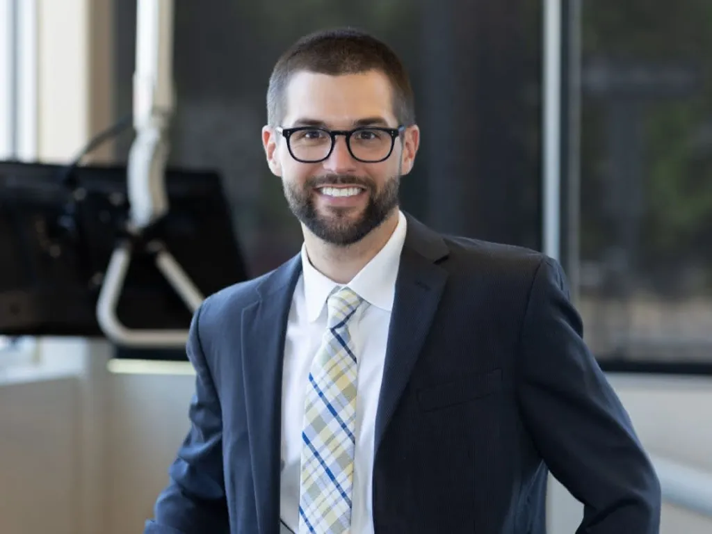 Dr. Adam Staffen in a suit smiling