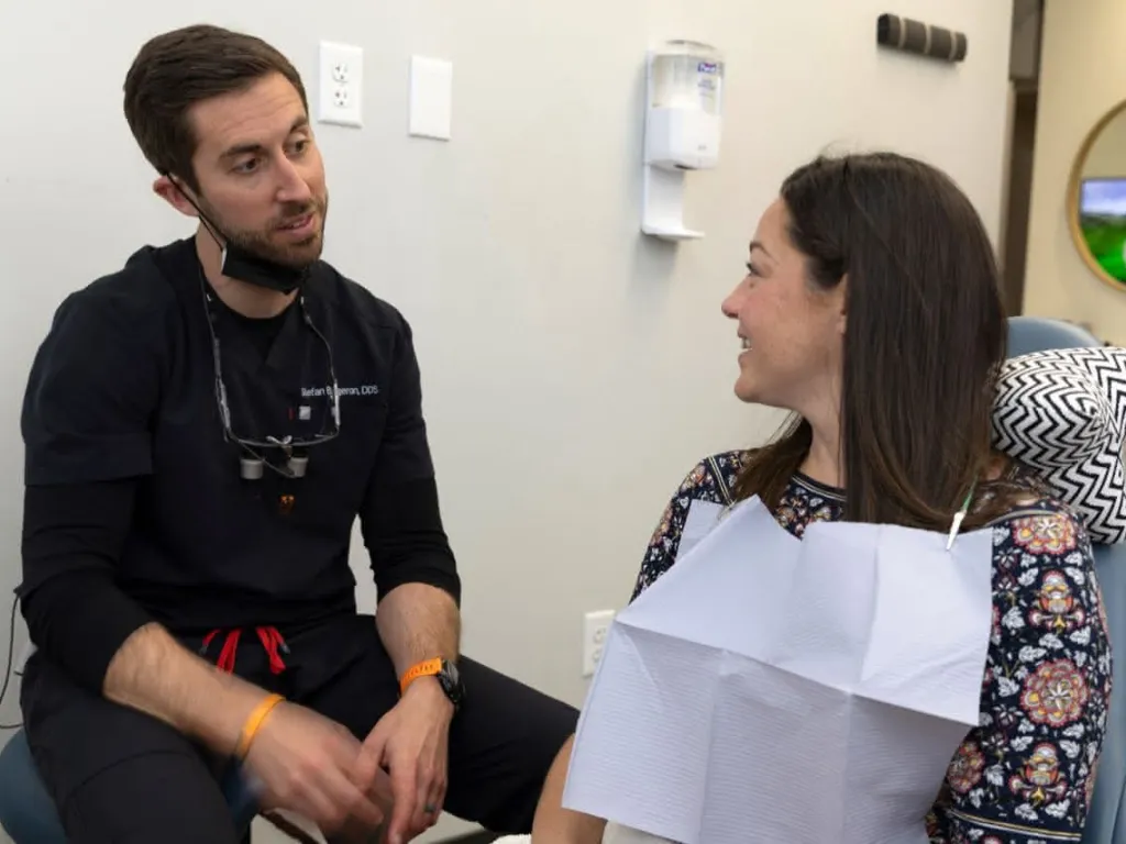 Dentist sitting with patient discussing procedures