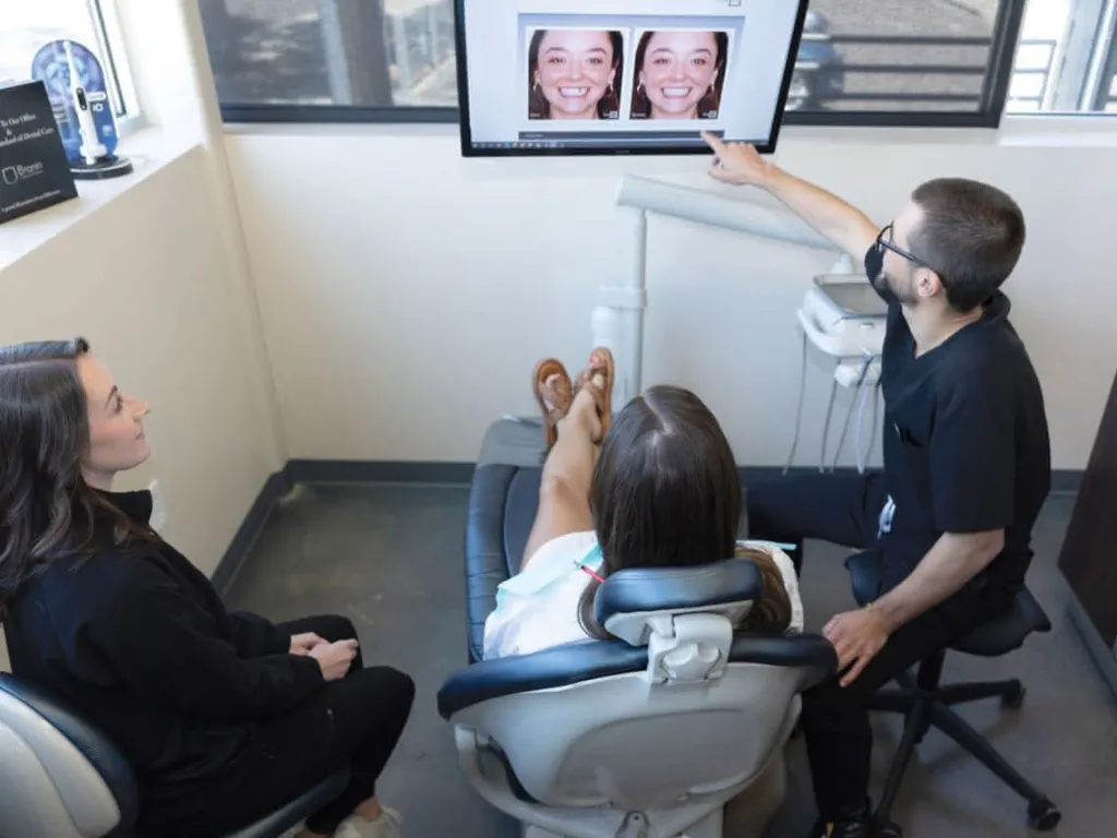 Doctor and hygienist with patient in char