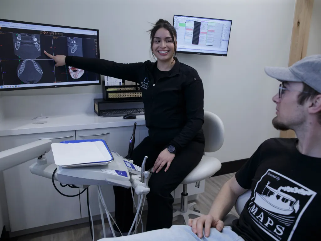 Superior team member showing x-rays to a patient.