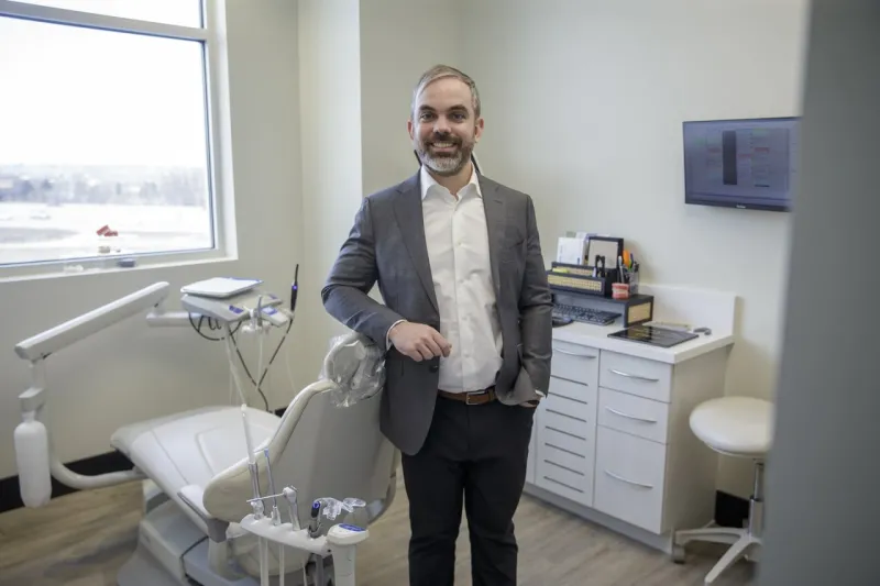 Dr. John Sporidis standing next to a dental chair