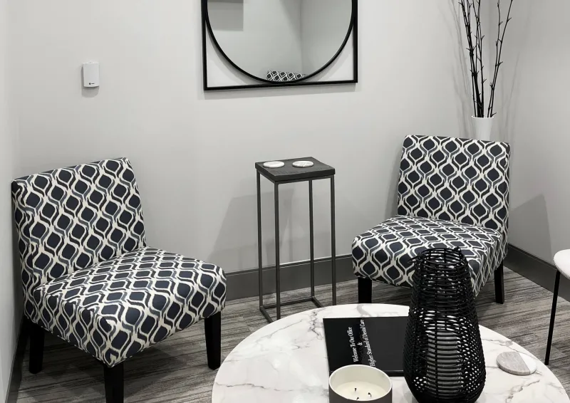 A waiting area with two black and white chairs