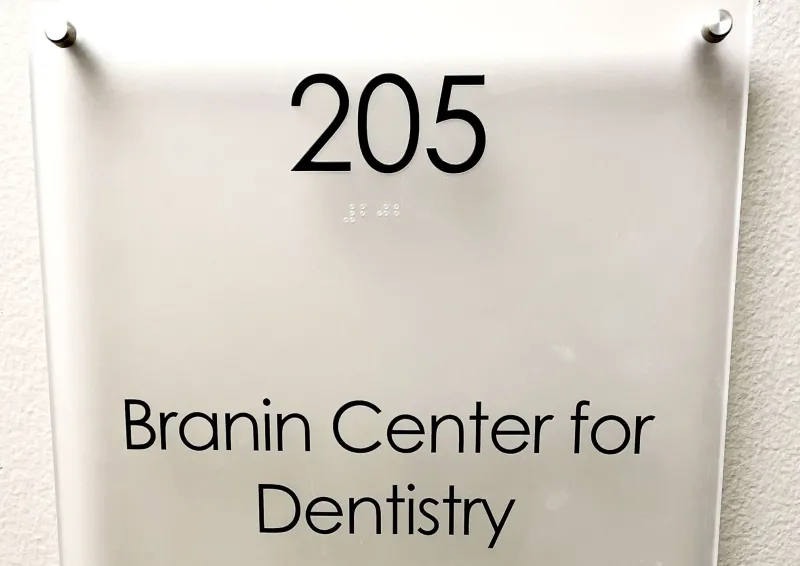 A glass door sign on a white wall