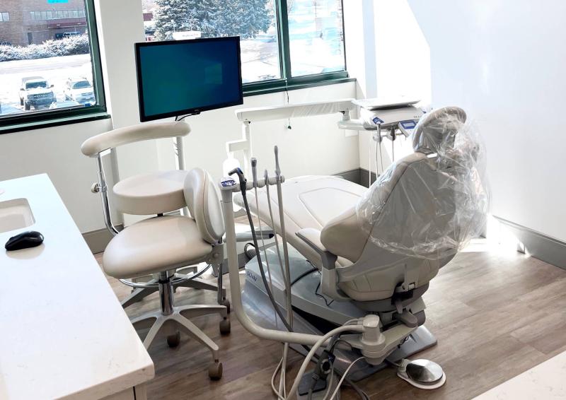 A large chair with a white wall and hardwood floors