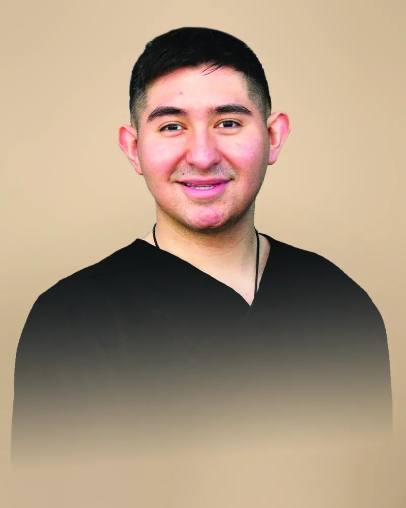 Edgar Hernandez in black shirt in front of tan background