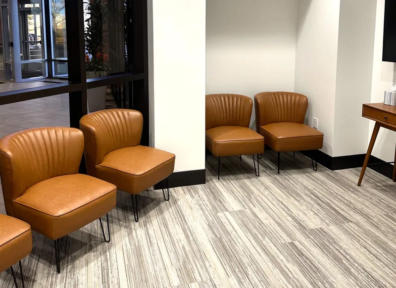 Dentist lobby with brown chairs and patterned wood flooring
