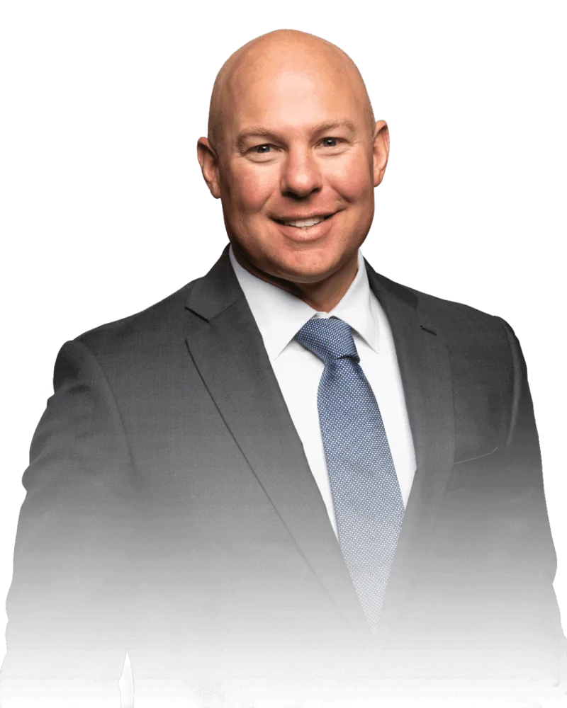 Scott Dudley in a dark suit on a tan background