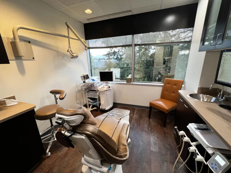 A dental examination room with dark hardwood floors