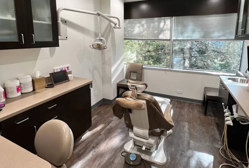 A dental exam room with many windows